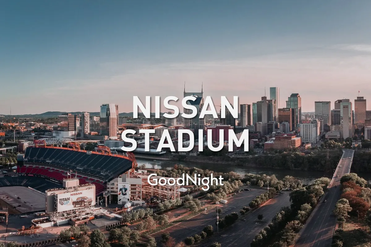 A panoramic view of Nissan Stadium with the city skyline in the background and the river winding through the scene. The stadium stands out as a vivid landmark, while the surrounding roads and buildings highlight Nashville's urban vibrancy and accessibility.